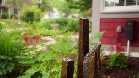 static-shot-of-a-water-fountain-with-three-spouts-in-the-front-of-a-home-during-the-day