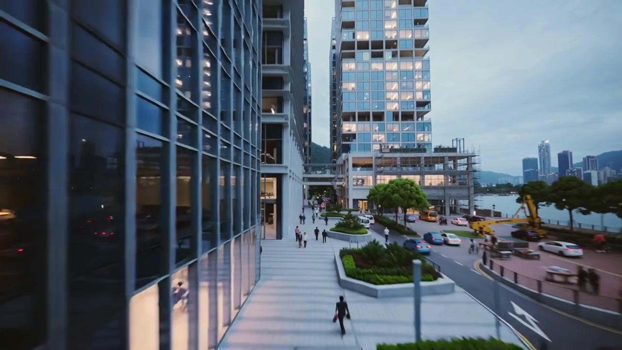 Drone in movimento che rivela adulti pendolari che camminano su una piazza sul lungomare al tramonto, mostrando le luci degli uffici.