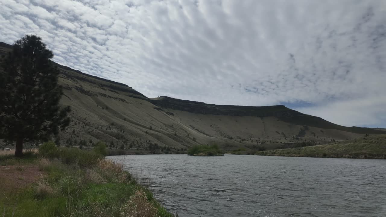 US, Oregon, Warm Springs, Deschutes River, 2025-05-04 - Panning hyperlapse of the Deschutes River near Warm Springs in spring. Clouds go by and the river flows.