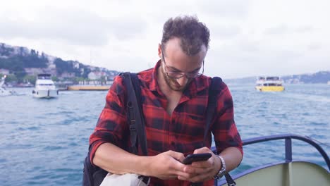 The-man-using-the-phone-on-the-ferry.