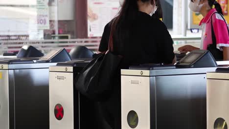 people entering and exiting through automated turnstiles