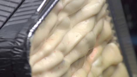 은박지에 지글지글 끓는 음식의 뜨겁게 타는 토치 불꽃과 함께 맛있고 맛있는 치킨 멘타이 치즈 표면 요리의 네덜란드 각도 보기 팬, 정적인 극단적인 클로즈업