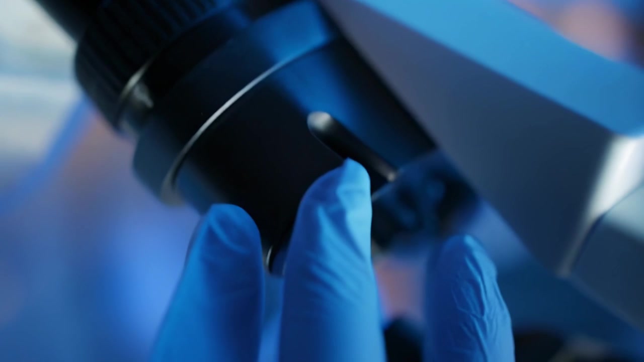 Close-up of Scientist Looking Through Microscope in Laboratory