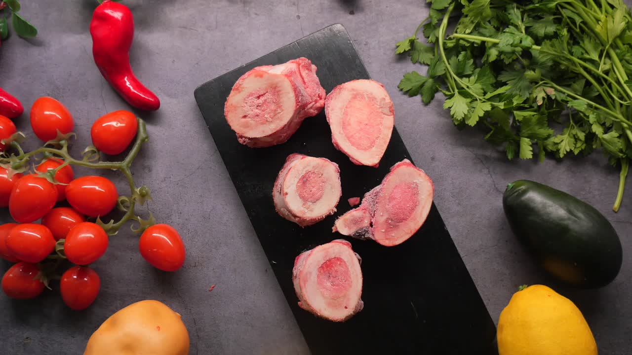 Xương tủy bò sống và rau củ tươi trên nền tối