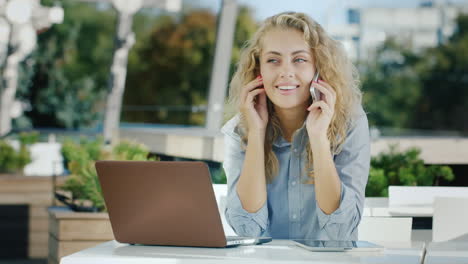 Attraktive-Geschäftsfrau,-Die-Telefoniert,-Sitzt-In-Einem-Café-Auf-Der-Terrasse-Und-Arbeitet-Mit-Einem-Laptop