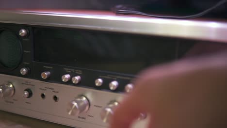 panning over an old amplifier, reaching for the on-button