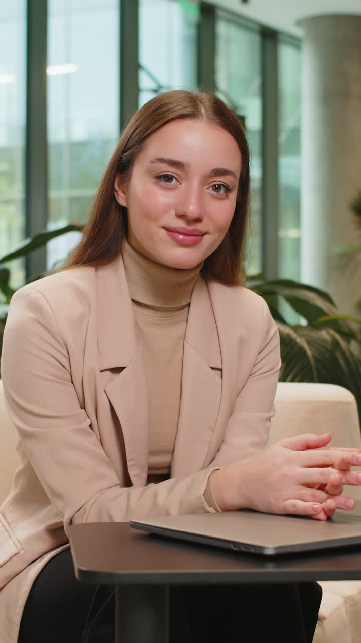 Portrait of smiling young businesswoman closing laptop computer after ...