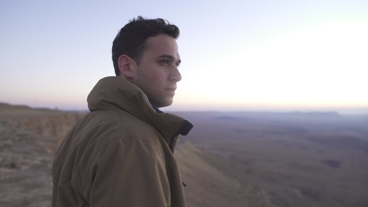 el hombre mira el sol naciente en un paisaje desértico