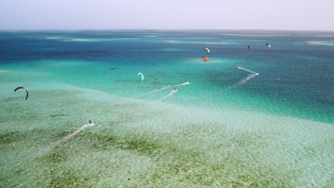 Kitesurfer-Gleiten-über-Klares,-Türkisfarbenes-Wasser-In-Einer-Atemberaubenden-Luftaufnahme