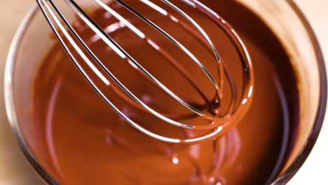 whisk mixing smooth melted chocolate in bowl