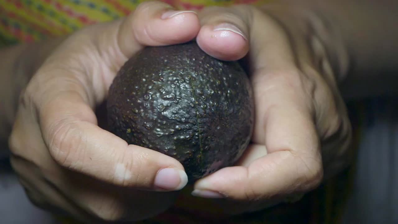 Avocado Halves Held in Hands