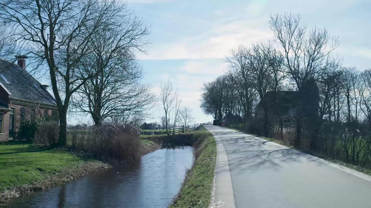 Rustige landweg met kanaal en traditionele boerderij
