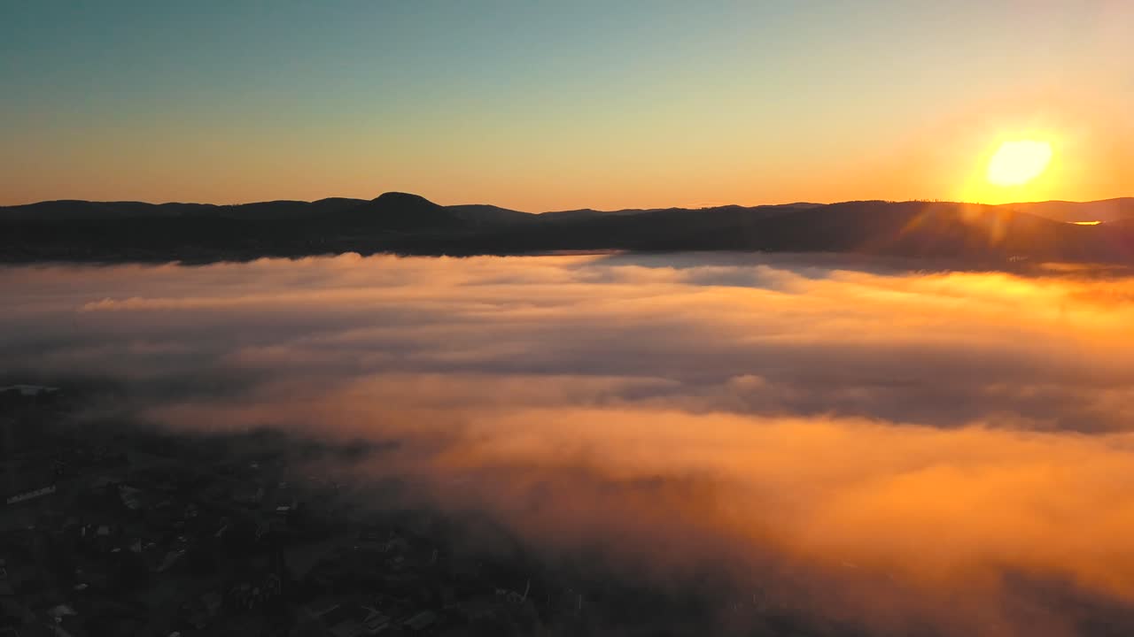 el sol estaba saliendo y la niebla de la mañana rodó sobre la ciudad y sobre las montañas