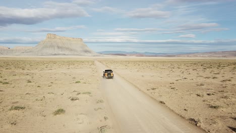 Stunning-aerial-shot-of-SUV-riding-through-desert-road