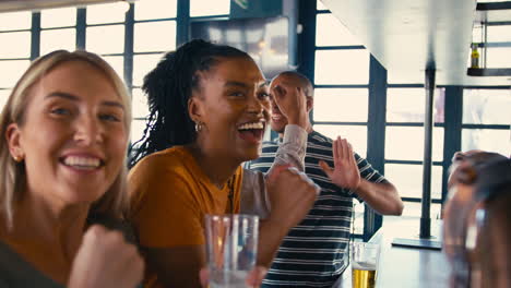 Grupo-Multicultural-De-Amigos-En-Un-Bar-Deportivo-Celebrando-Mientras-Ven-Partidos-En-La-Televisión.