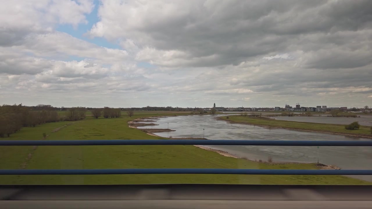 View from a car driving on the A1 highway over the IJssel river with Deventer skyline in background