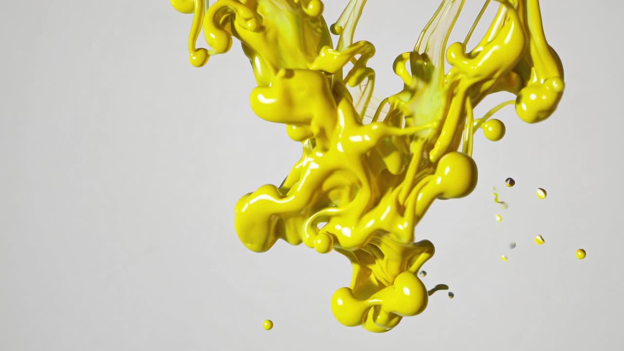 Dynamic close-up video of vibrant yellow paint splashing against a white background