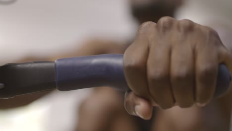 mans hands whilst rowing in gym