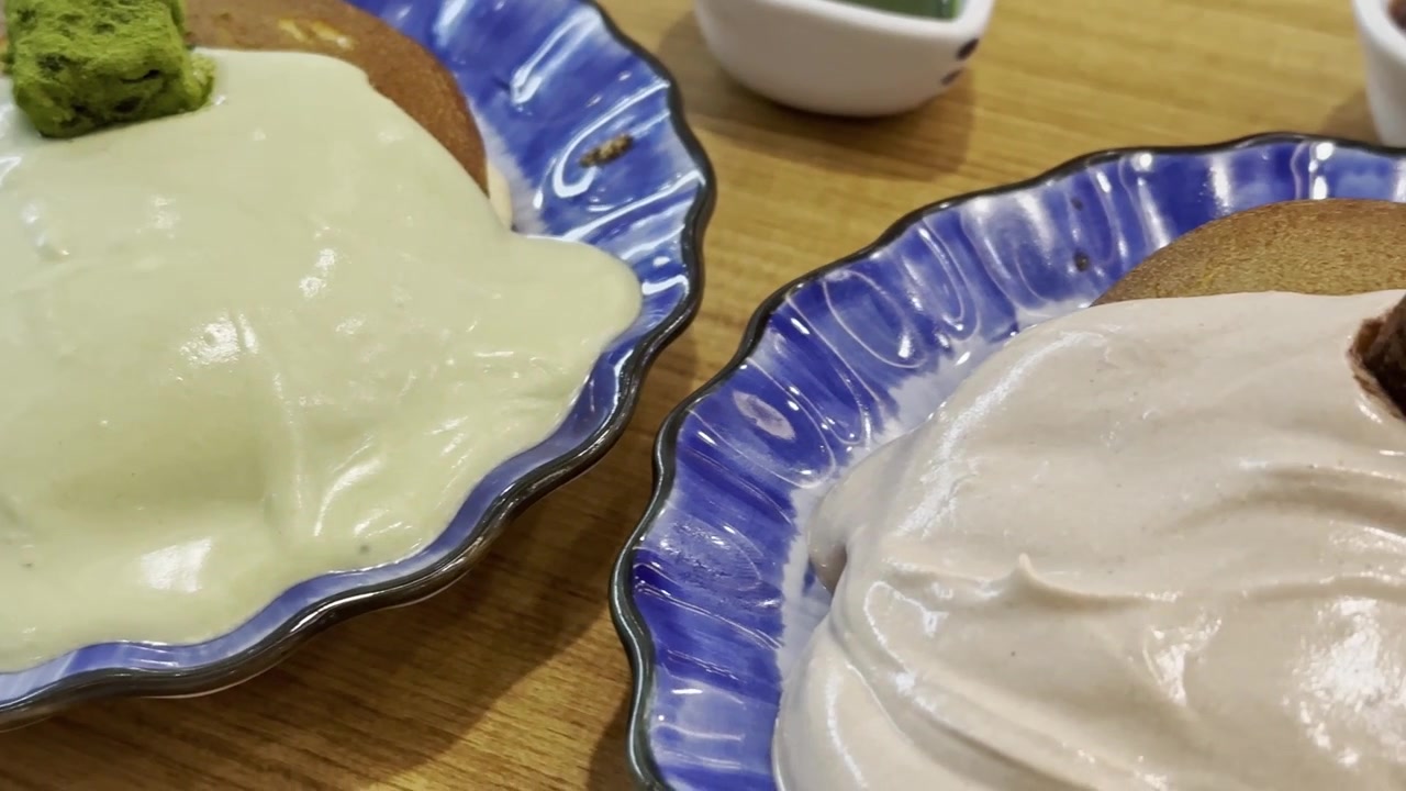 Primo piano di pancake al matcha in stile giapponese irrorati con salsa al cioccolato e guarniti con ricco cioccolato nama, creando un dessert goloso con una presentazione elegante.