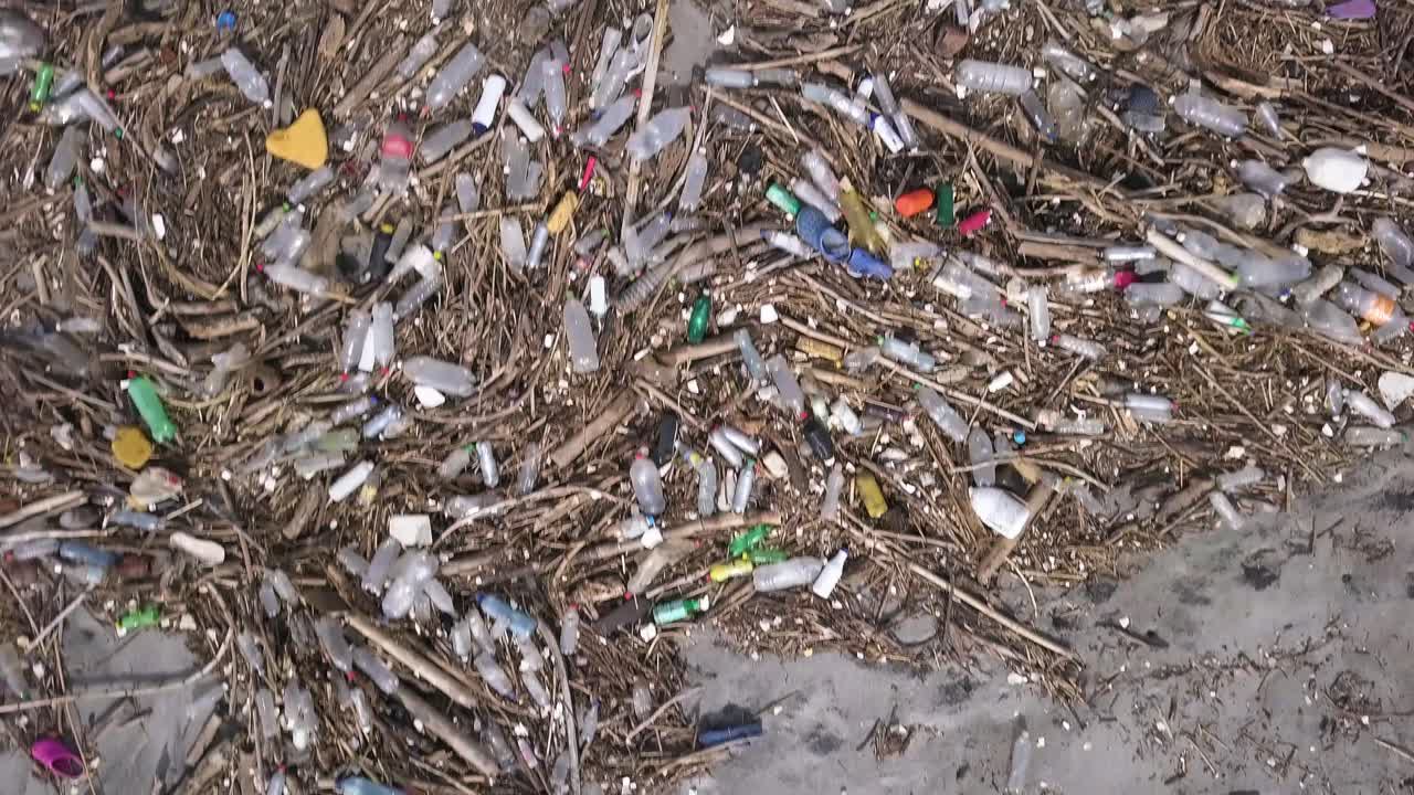 많은 플라스틱 병과 기타 쓰레기로 해변을 오염시키는 쓰레기 - 바로 위의 공중