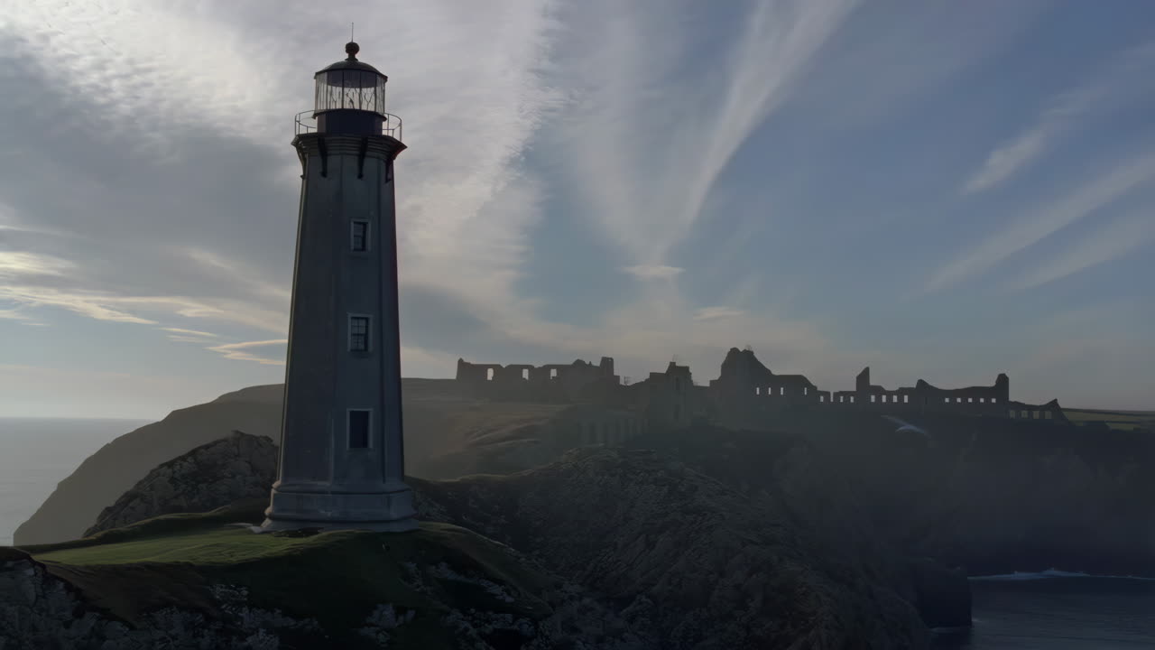 Dramatic Coastal Landscape with Lighthouse and Distant Ruins