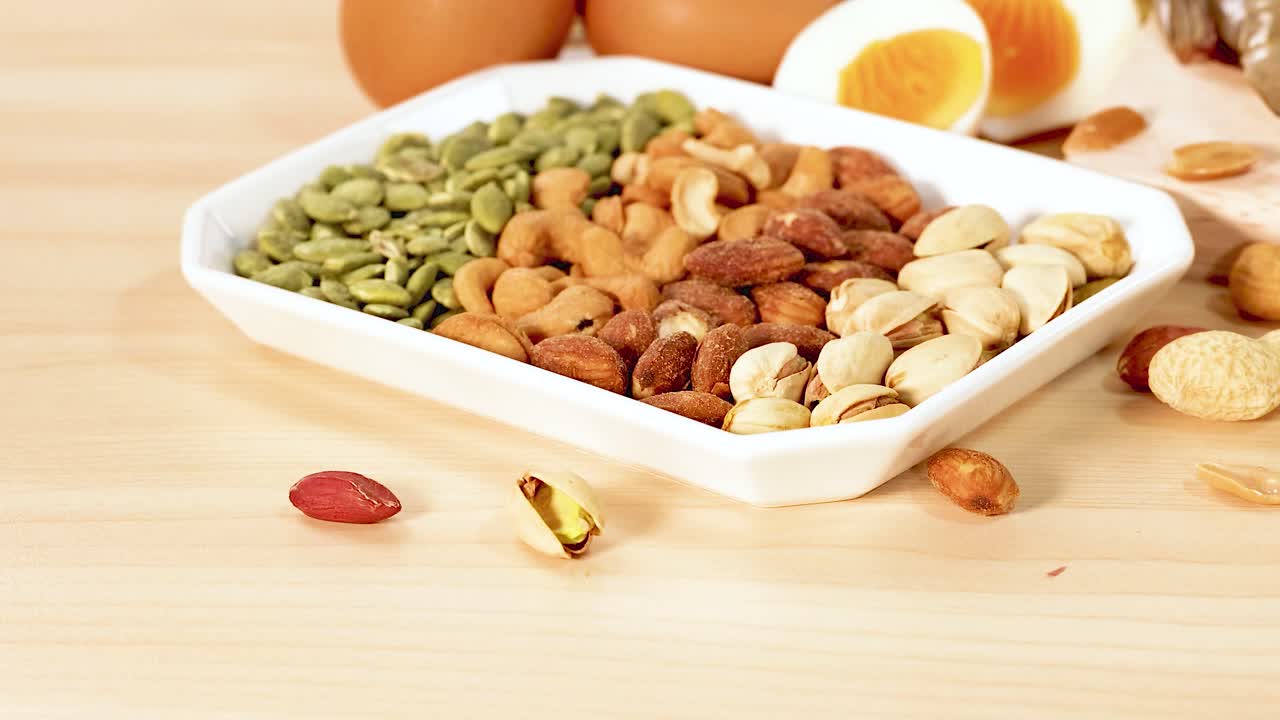 견과류, 달, 유제품 등 단백질이 풍부한 다양한 음식들이 나무 테이블 위에 예술적으로 배열되어 있습니다.