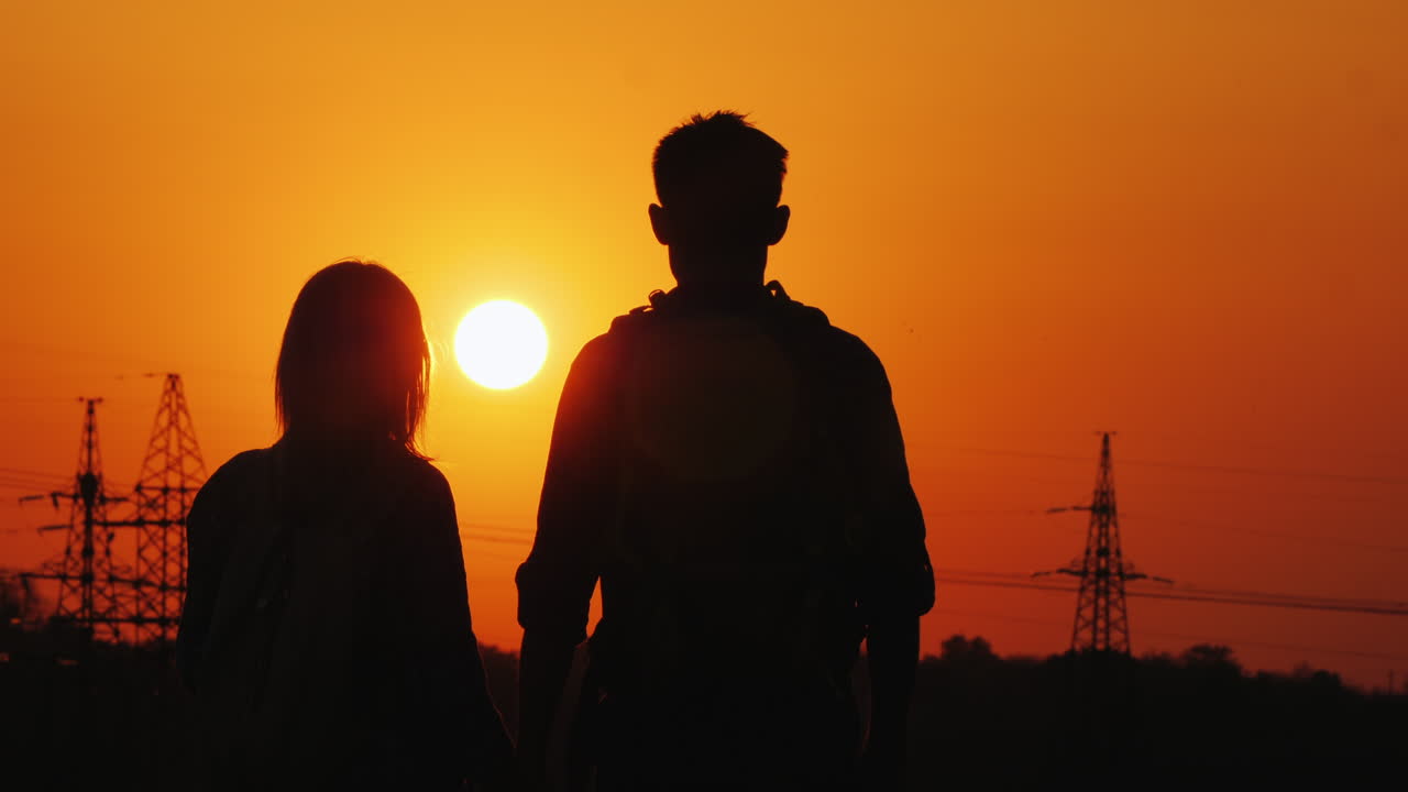 도시 후면의 일몰을 감상하는 관광객 두 명