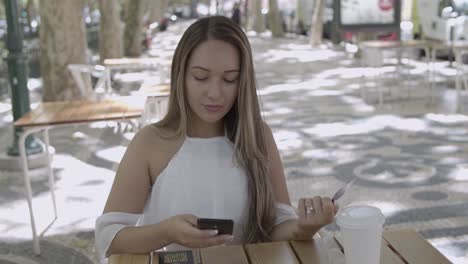 mujer de pelo largo que realiza el pago a través de un teléfono inteligente