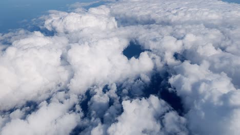 high altitude perspective thick cloud cover floating above endless ocean textured waves glimmering below soft gradients of blue dominate frame