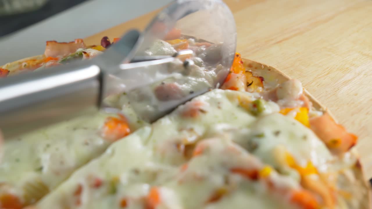 acaba de cocinar la pizza del horno cortada en pedazos con el cuchillo de la pizza.