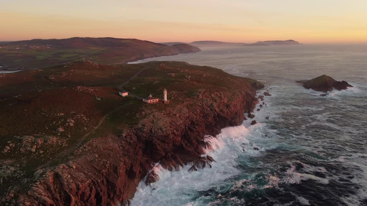 las olas chocan en la costa del faro de cabo tourinan durante la puesta de sol