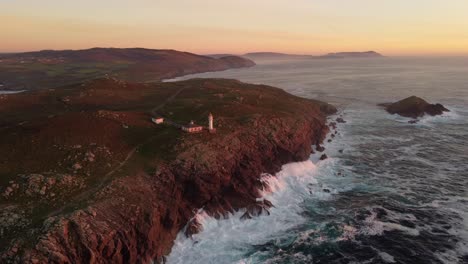 Las-Olas-Chocan-En-La-Costa-Del-Faro-De-Cabo-Tourinan-Durante-La-Puesta-De-Sol