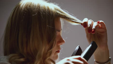 mujer que se estila el cabello con una plancha de cabello