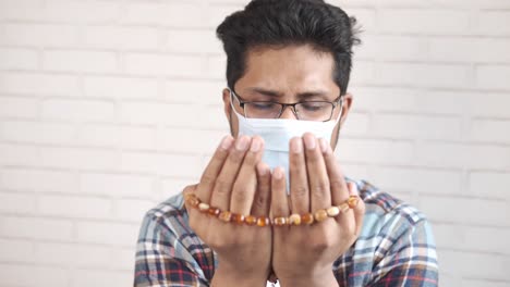 man praying with mask during pandemic