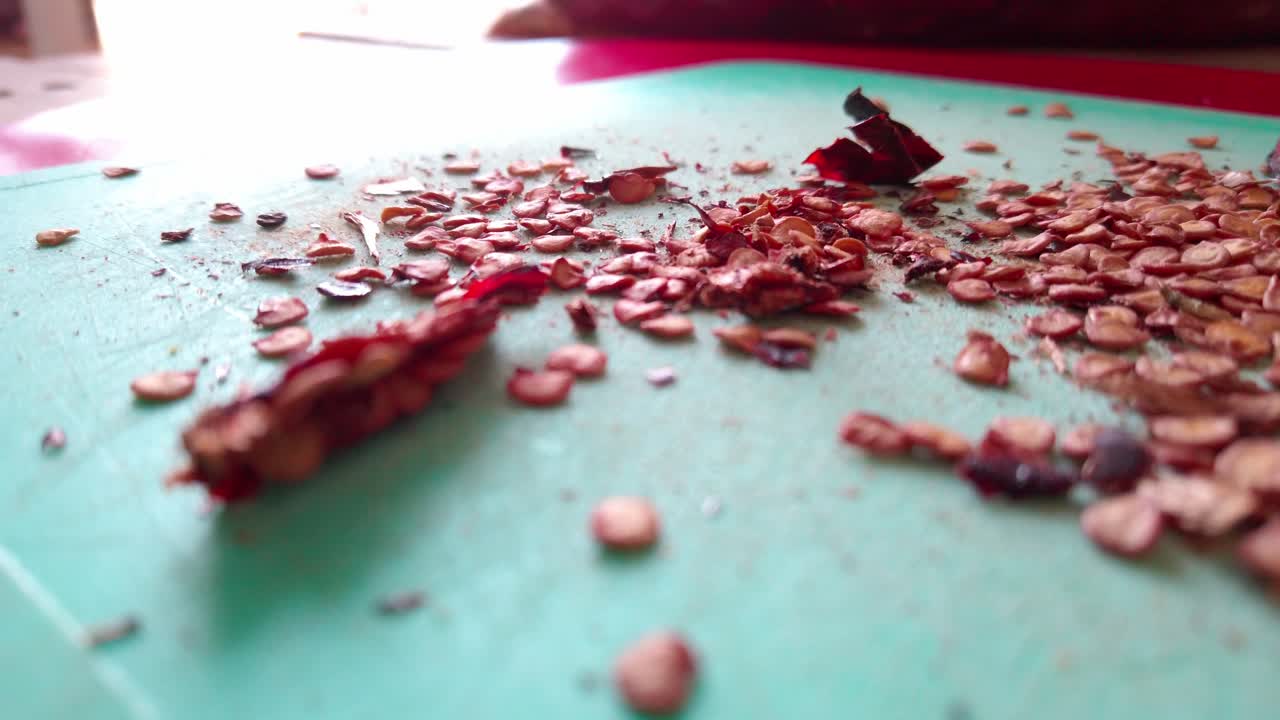 Handheld shot of crushed guajillo chili on a table during the day, indoor