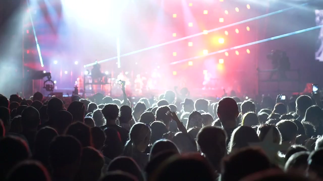 Folla energica a un concerto di musica dal vivo con luci di scena brillanti