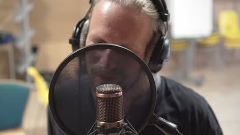 condenser microphone and pop filter with singer, high angle extreme closeup