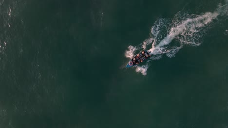 top-down shot of a small fishing boat returning back to the mozambique shore