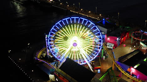 aerial view of the illuminated pacific park ferris wheel at santa monica pier at night