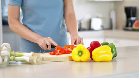mujer preparando verduras en la tabla de cortar