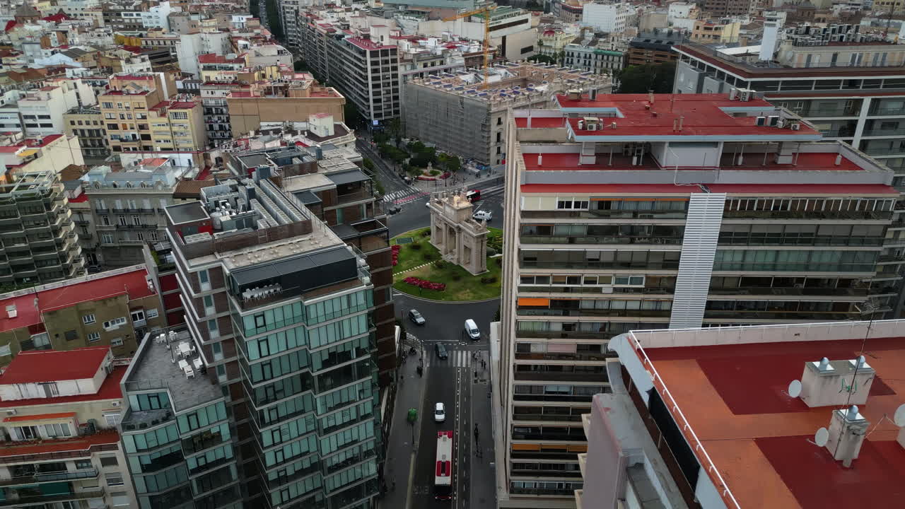 Vista aérea de drone de carros em movimento nas ruas entre os edifícios, perto da Porta De La Mar em Valência, Espanha, durante o dia