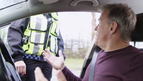 angry male driver being stopped by female traffic police officer for driving offence