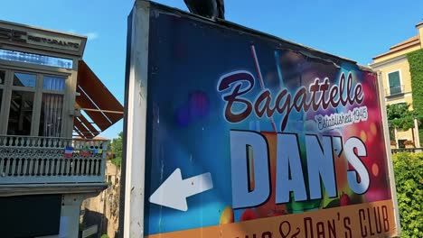 pigeon flies past a vibrant club sign