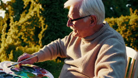 senior man painting outdoors in his garden