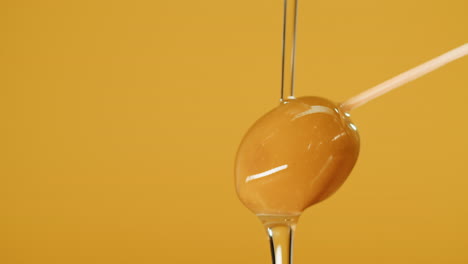 olive oil dripping onto a wooden stick