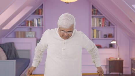 sad indian old man measuring waist using inch tape