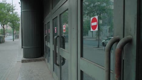 row of doors with red do not enter forbidden stickers, detail from sidewalk