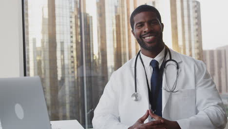 Portrait-Of-Smiling-Male-Doctor-With-Stethoscope-In-Hospital-Office