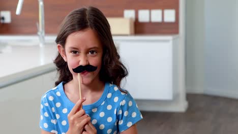 cute child with fake mustaches making faces