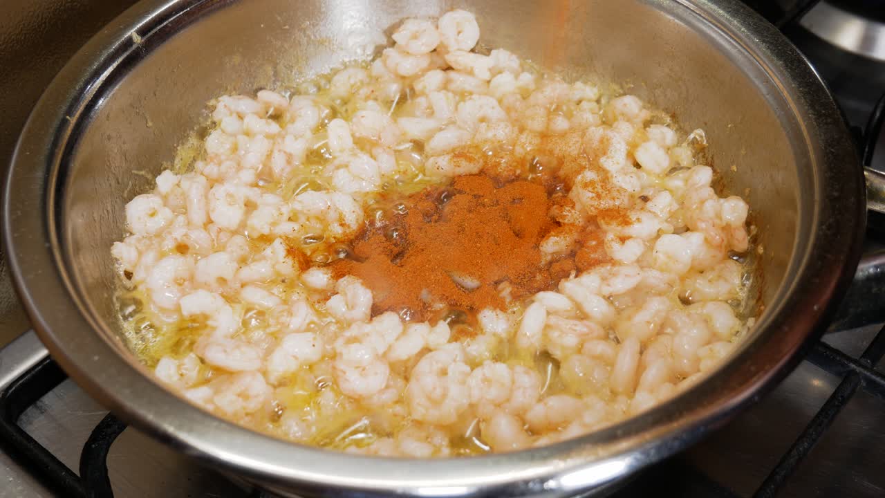verter polvo de pimiento en camarones recién cocinados